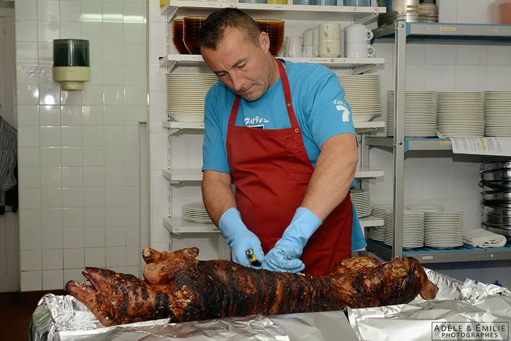 Serge Duval découpe un cochon grillé